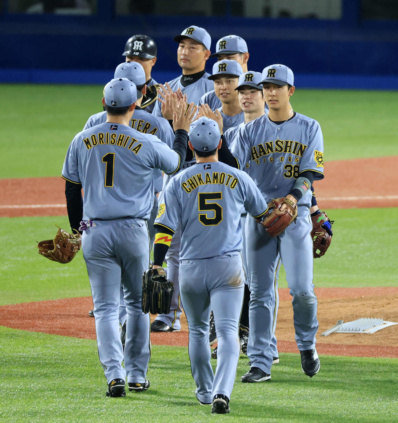 ヤクルト対阪神　延長戦を制しハイタッチで喜び合う熊谷（中央）ら阪神の選手たち（撮影・浅見桂子）