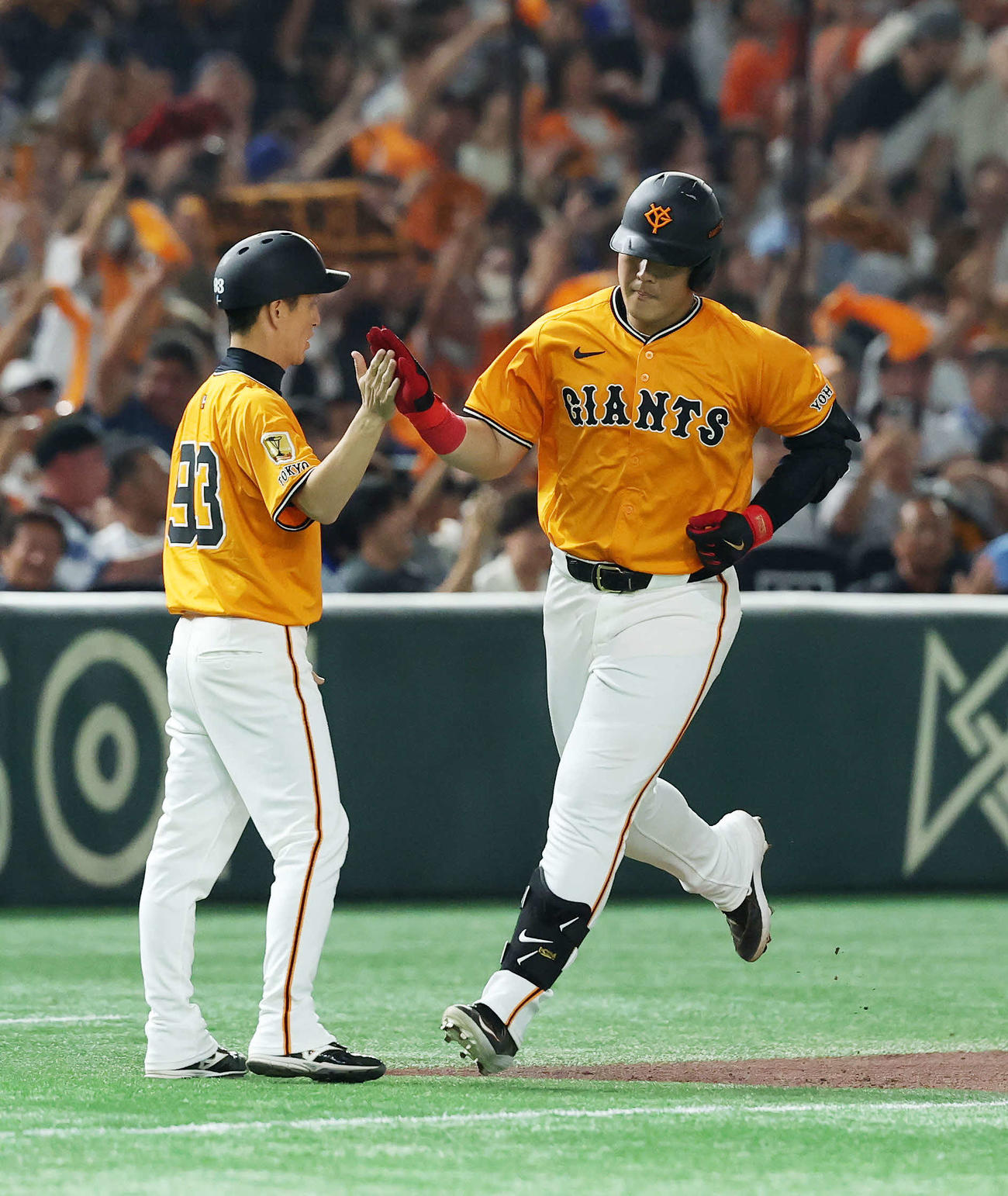 巨人対DeNA 3回裏巨人2死、岡本（右）は左中間ソロ本塁打を放ち松本コーチとタッチ（撮影・鈴木正人）