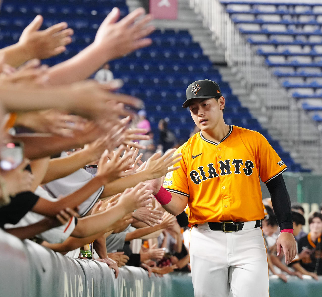 巨人対DeNA　試合後、ファンとタッチを交わす巨人岡本（撮影・江口和貴）
