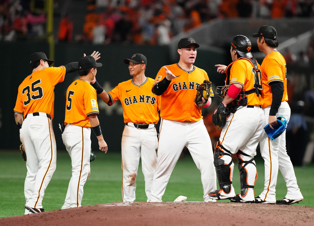 巨人対DeNA　試合後、勝利のタッチを交わすリチャード（中央右）ら巨人の選手たち。同左は吉川（撮影・江口和貴）