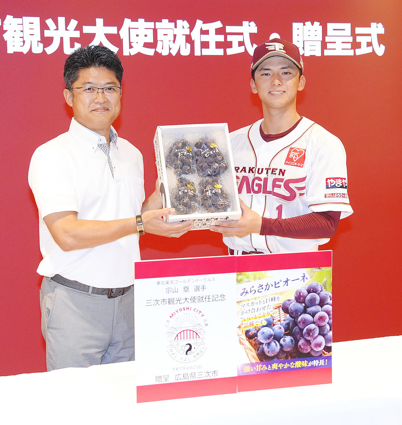 出身地の広島県三次市観光大使に就任した楽天宗山（右）は三次市の福岡市長からぶどうを贈られ笑顔（撮影・足立雅史）