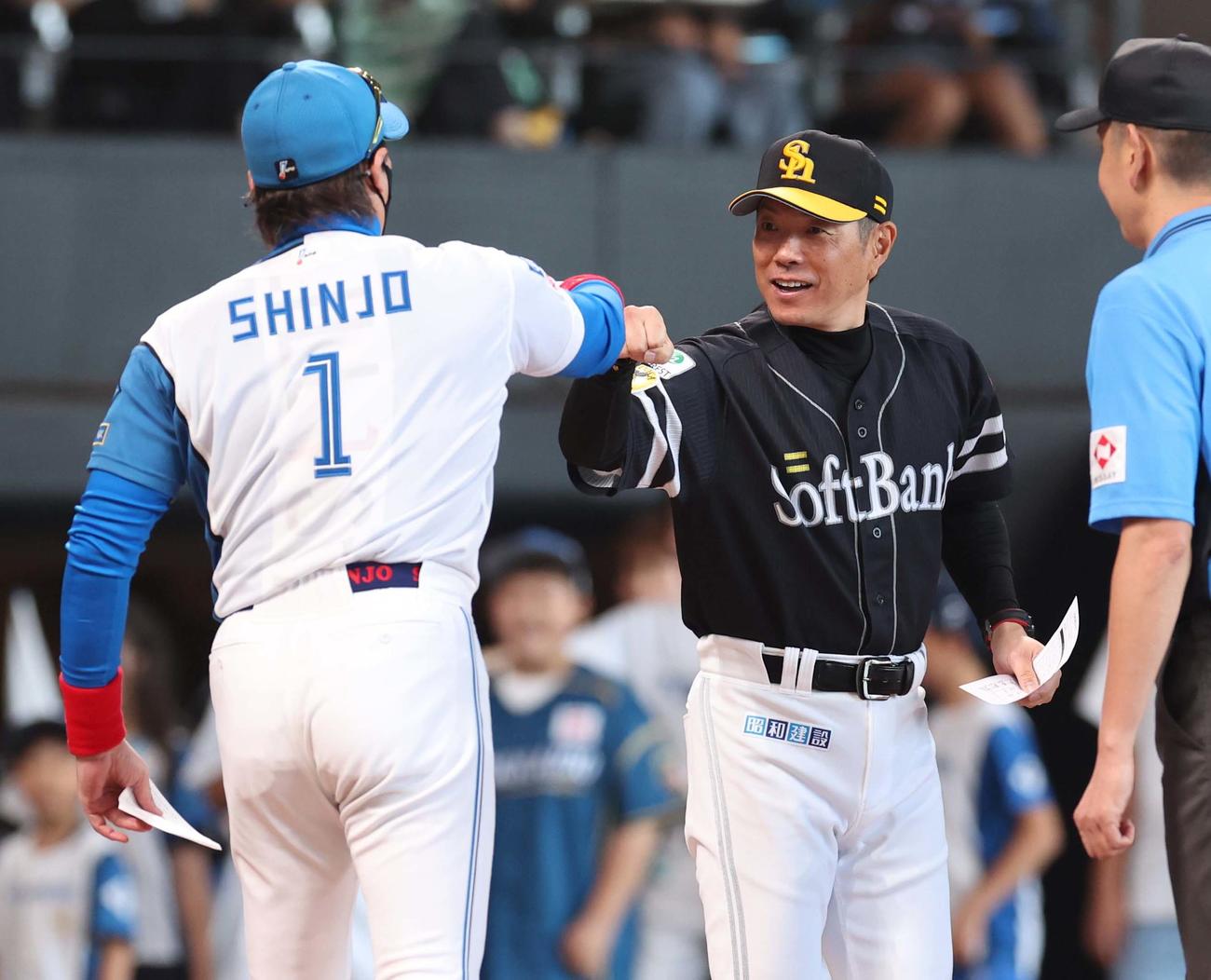 日本ハム対ソフトバンク　メンバー表交換で小久保監督（右）とグータッチする新庄監督（撮影・黒川智章）