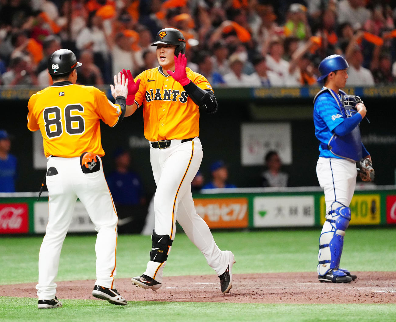 巨人対DeNA 7回裏巨人1死、2打席連続となるソロ本塁打を放ち、タッチを交わす岡本（中央）（撮影・江口和貴）