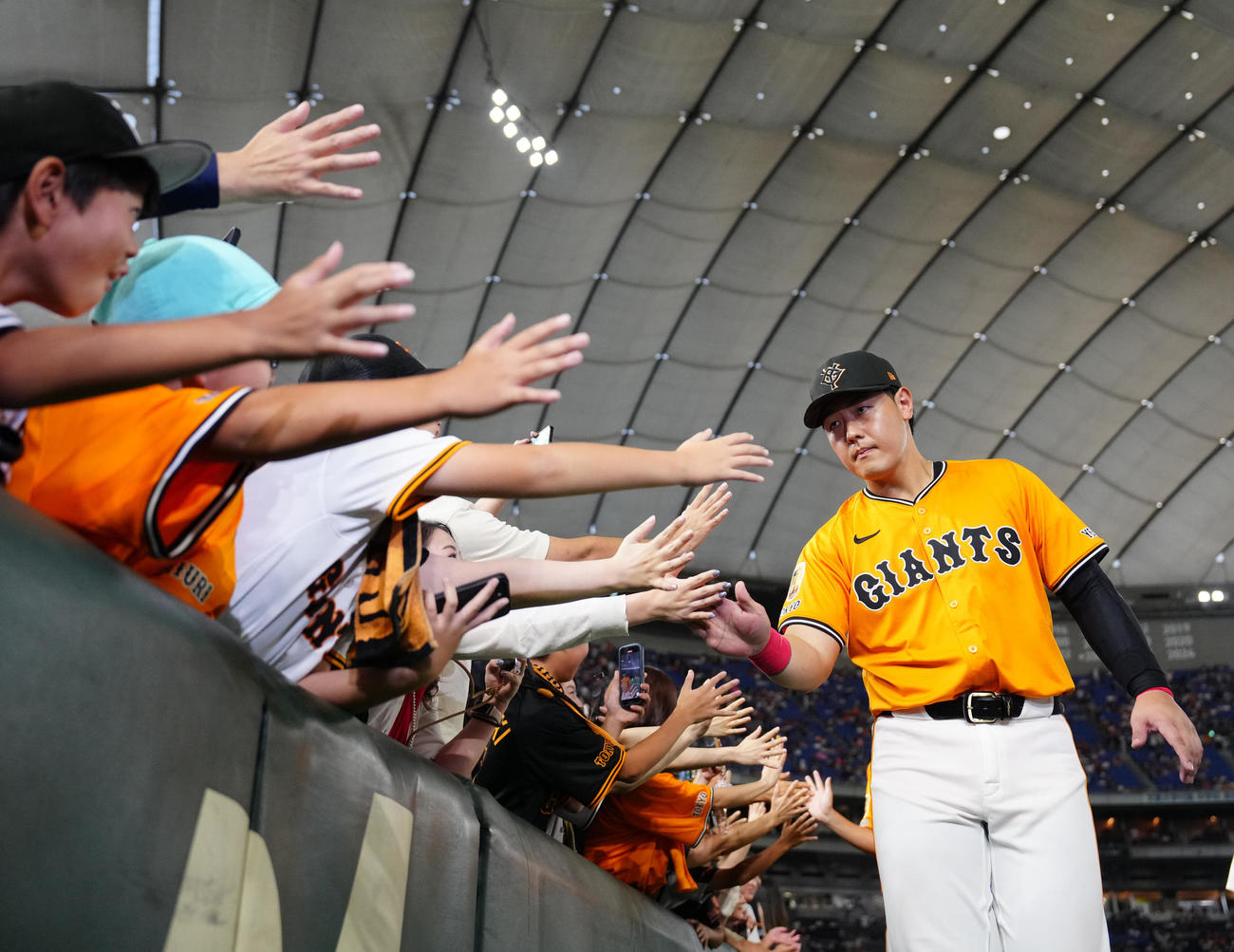 巨人対DeNA　試合後、ファンとタッチを交わす巨人岡本（撮影・江口和貴）