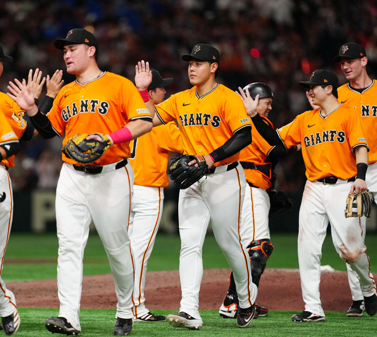 巨人対DeNA　試合後、勝利のタッチを交わす巨人岡本（中央）。左はリチャード（撮影・江口和貴）