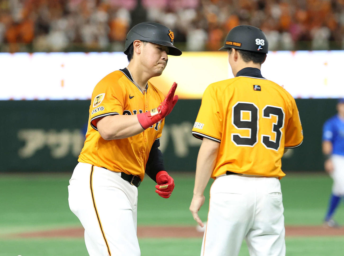 巨人対DeNA 5回裏巨人無死、岡本（左）は左越えソロ本塁打を放ち松本コーチとタッチ（撮影・鈴木正人）