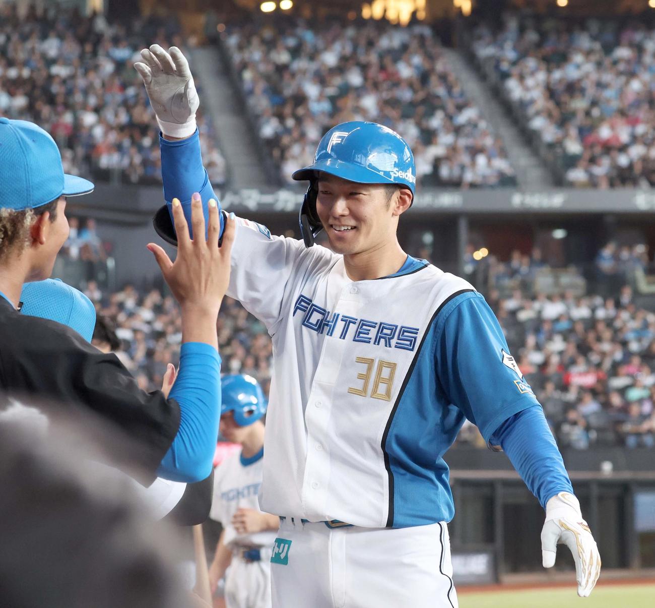 日本ハム対ソフトバンク　7回裏、本塁打を放った石井はナインに出迎えられ笑顔（撮影・黒川智章）