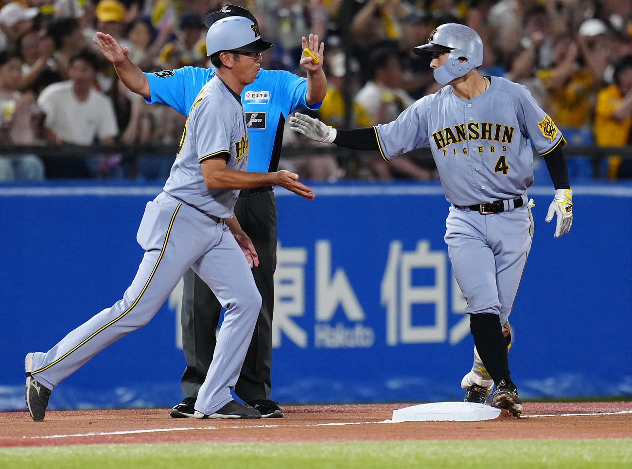 ヤクルト対阪神　5回表阪神1死、右三塁打を放った熊谷（右）とタッチを交わす田中内野守備走塁コーチ（撮影・鈴木みどり）