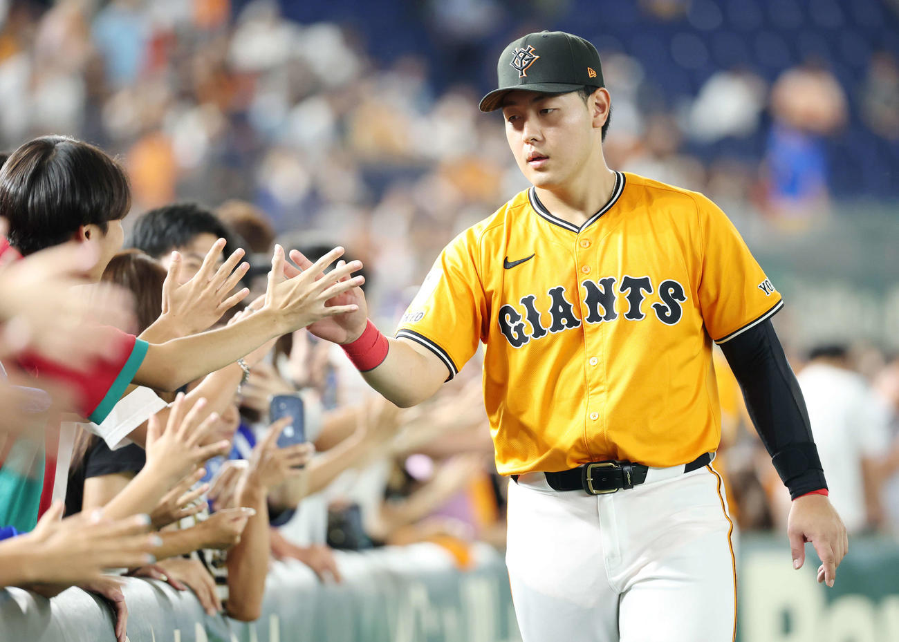 ファンとタッチする巨人岡本（2025年8月23日撮影）