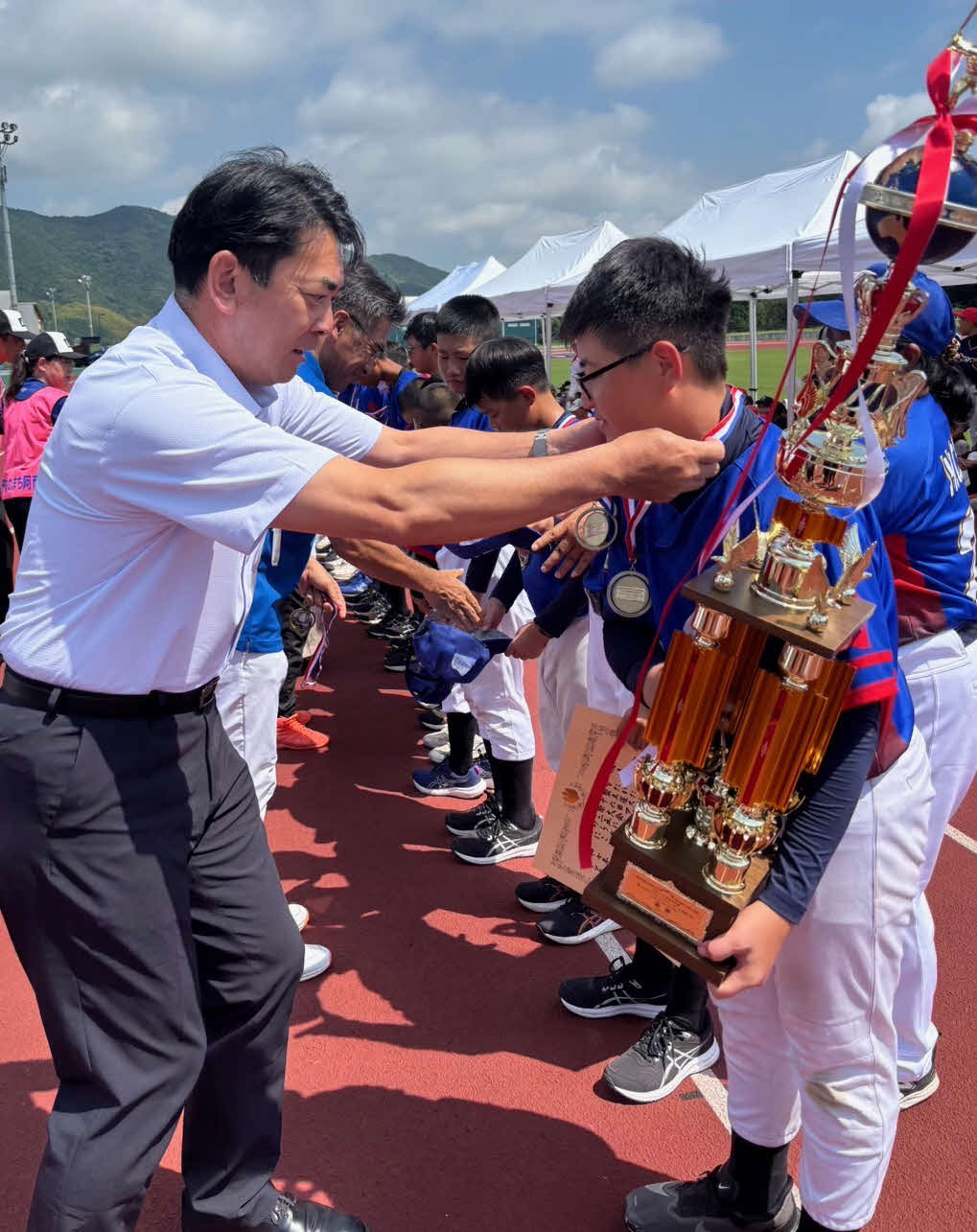ティーボールのアジア大会を制した台湾の選手たちは岩佐義弘阿南市長からメダルをかけられる（大会関係者提供）