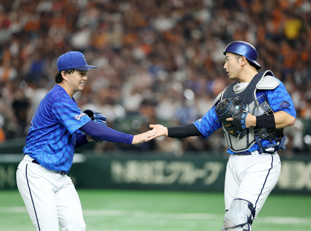 巨人対DeNA 1回裏、巨人の攻撃を抑えタッチするDeNA竹田（左）と山本（撮影・鈴木正人）
