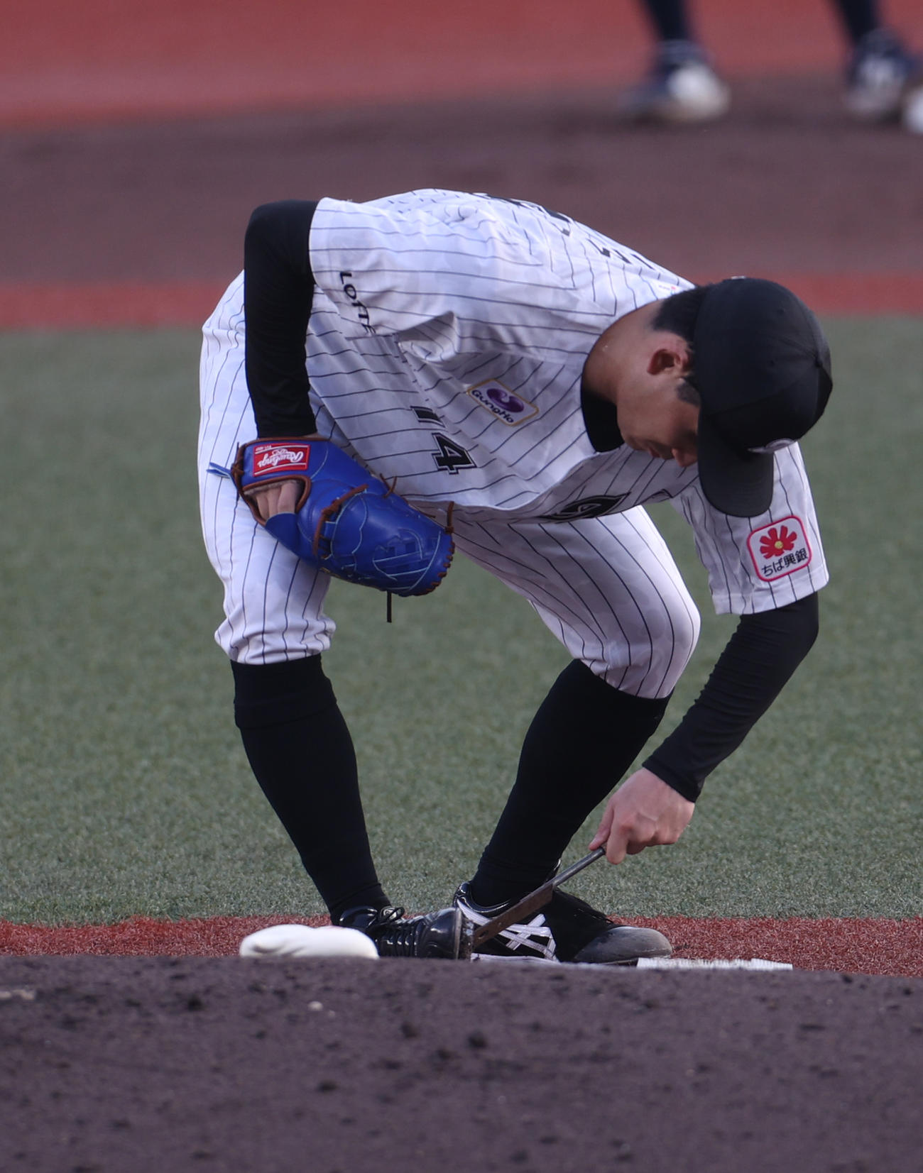 ロッテ対西武　スパイクに付いた土を落とすロッテ先発の小島（撮影・水谷安孝）