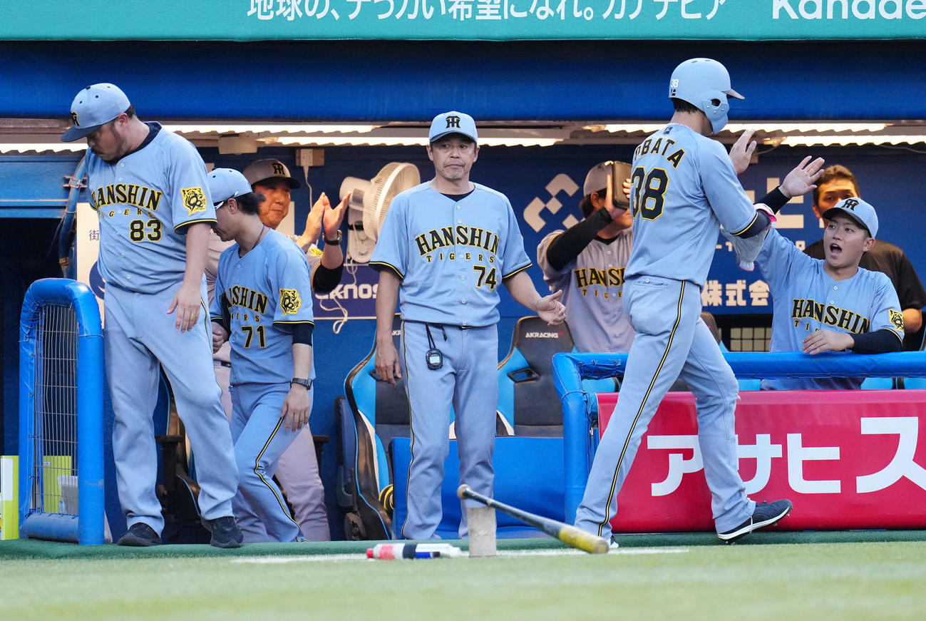 ヤクルト対阪神　3回表阪神2死一、二塁、中野の先制の中前適時打で生還した二塁走者小幡（右手前）に拍手する藤川監督（左奥）（撮影・鈴木みどり）