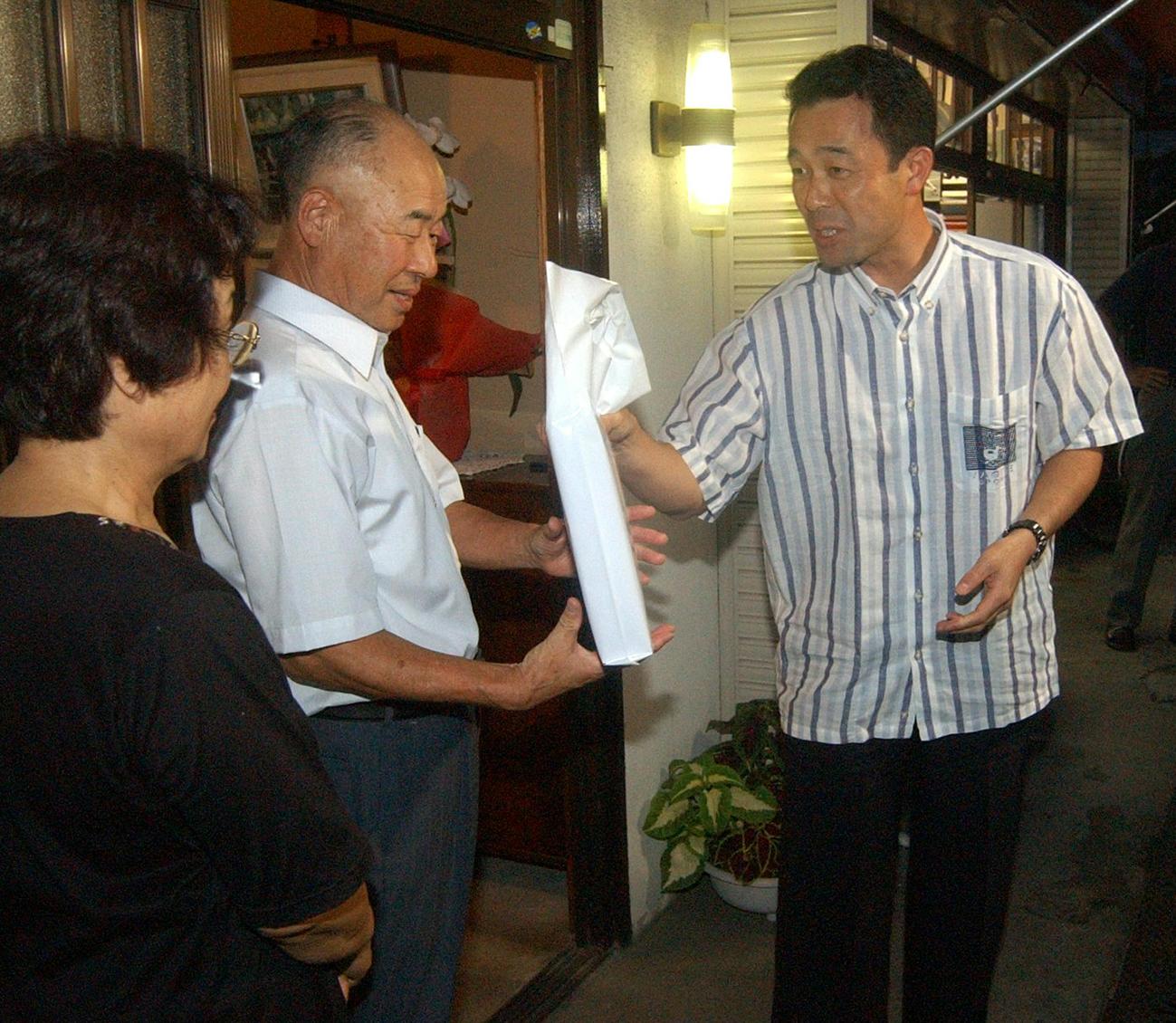 2003年9月、川相昌弘帰省　犠打世界記録を達成した川相昌弘（右）はがい旋帰省し、父禎一さんと母時子さんの出迎えを受ける