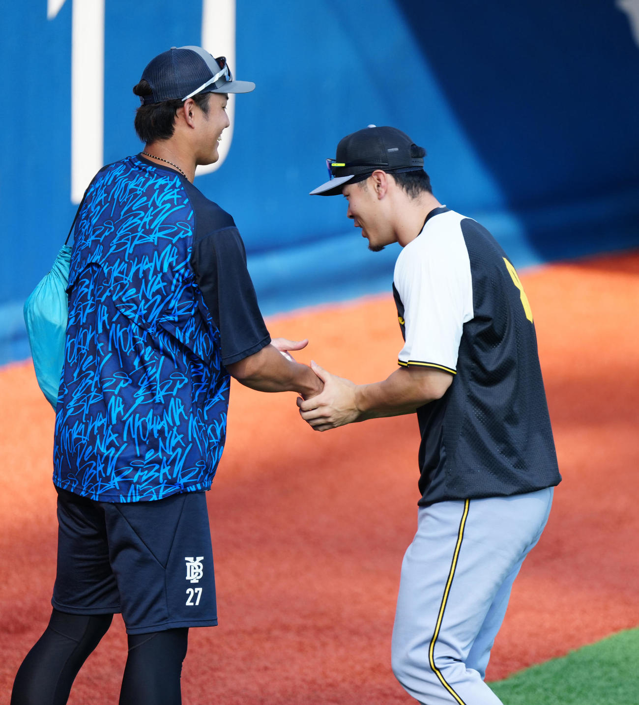 DeNA対阪神　試合前練習中、握手を交わすDeNA藤浪（左）と阪神佐藤輝（撮影・江口和貴）