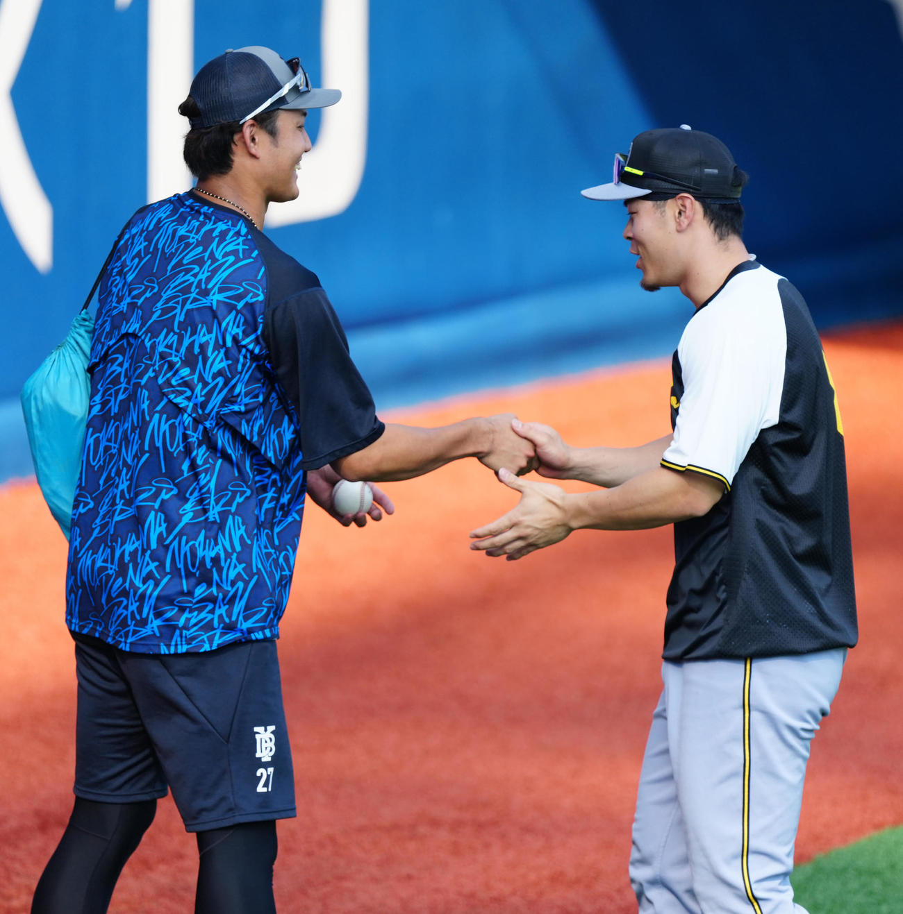 DeNA対阪神　試合前練習中、握手を交わすDeNA藤浪（左）と阪神佐藤輝（撮影・江口和貴）