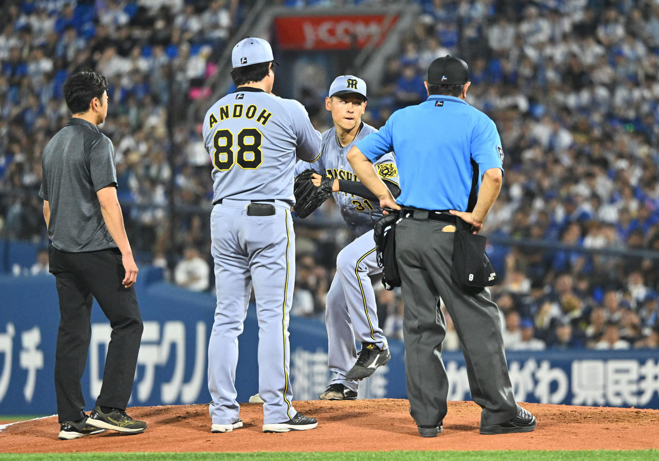 DeNA対阪神　4回裏途中にベンチ裏へ引き揚げた阪神先発の早川はマウンドに戻り安藤コーチに見守られ投球練習する（撮影・滝沢徹郎）