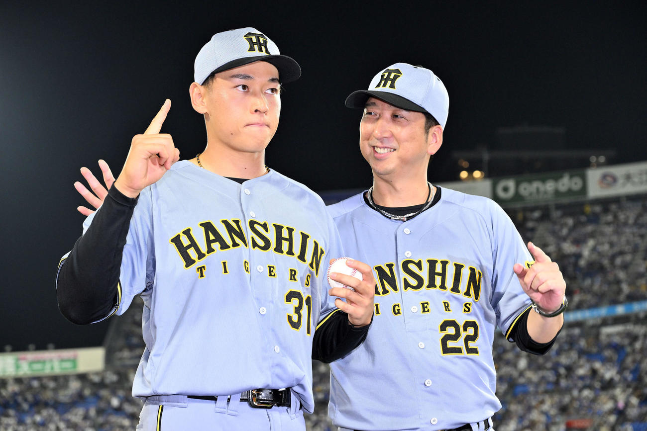 DeNA対阪神　試合後、プロ初勝利の記念撮影をする阪神早川（左）を見守る藤川監督（撮影・滝沢徹郎）