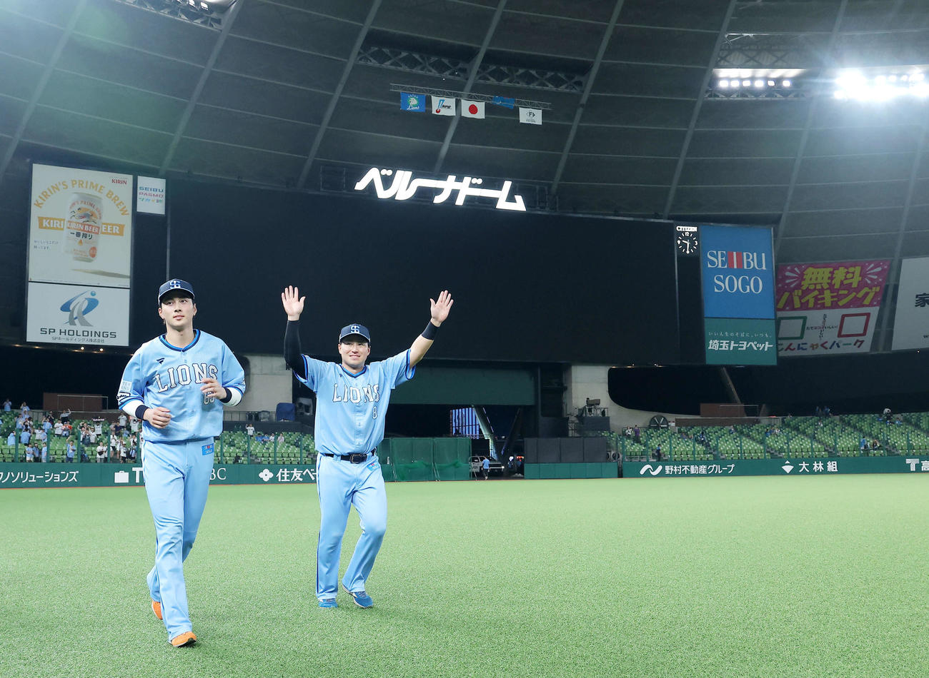 西武対日本ハム　場内一部停電のためヒーローインタビューは行われず、ファンの声援に応えながら引き揚げる西武長谷川（左）と渡部聖（撮影・河田真司）