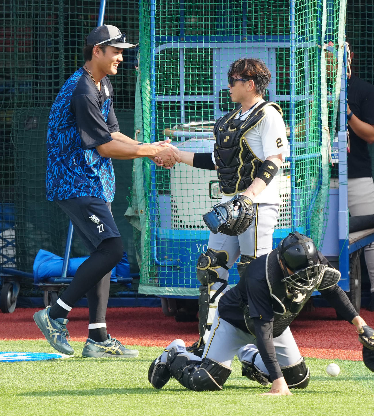 DeNA対阪神　試合前練習中、握手を交わす阪神梅野（右）とDeNA藤浪（撮影・江口和貴）