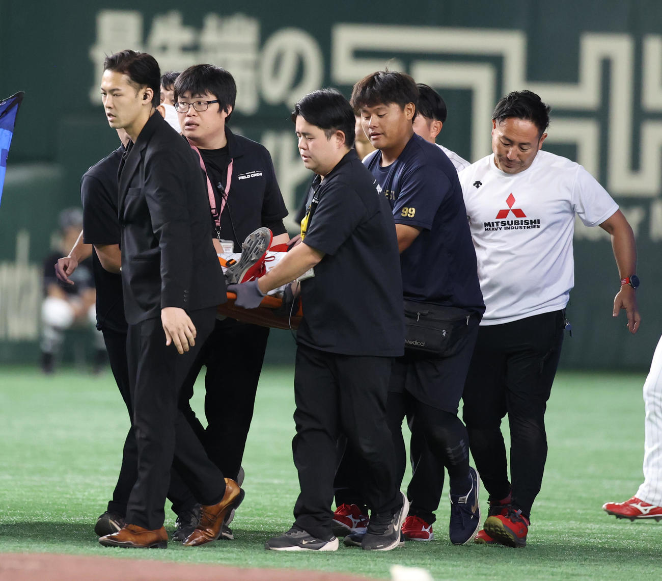 NTT西日本対三菱重工East 2回表NTT西日本無死、浜田の左飛をフェンスに激突した江越海左翼手は負傷し担架で運ばれる（撮影・柴田隆二）　　