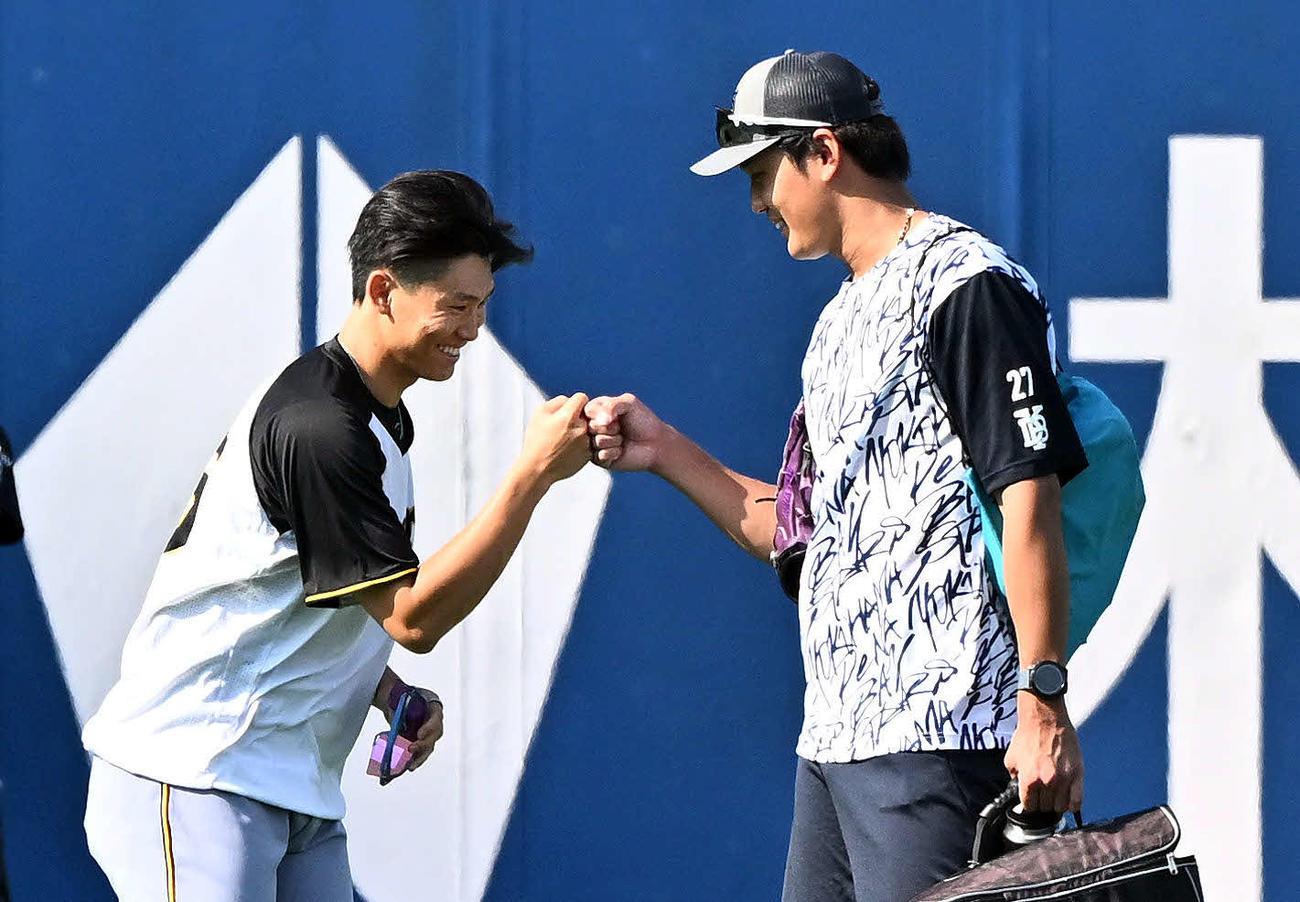 DeNA対阪神　試合前練習でグータッチする阪神湯浅（左）とDeNA藤浪（撮影・滝沢徹郎）