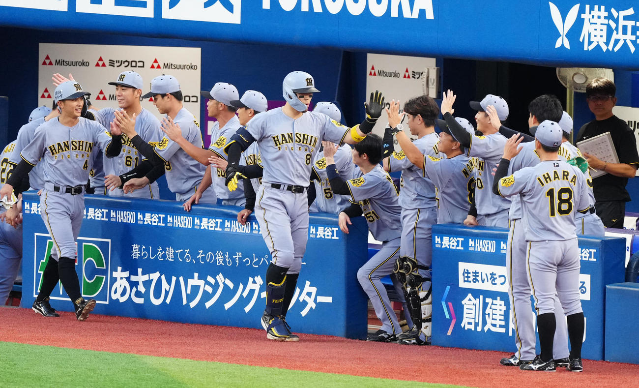 DeNA対阪神　1回表阪神2死二塁、先制2点本塁打を放ち、チームメートとタッチを交わす佐藤輝（中央）。左端は熊谷（撮影・江口和貴）