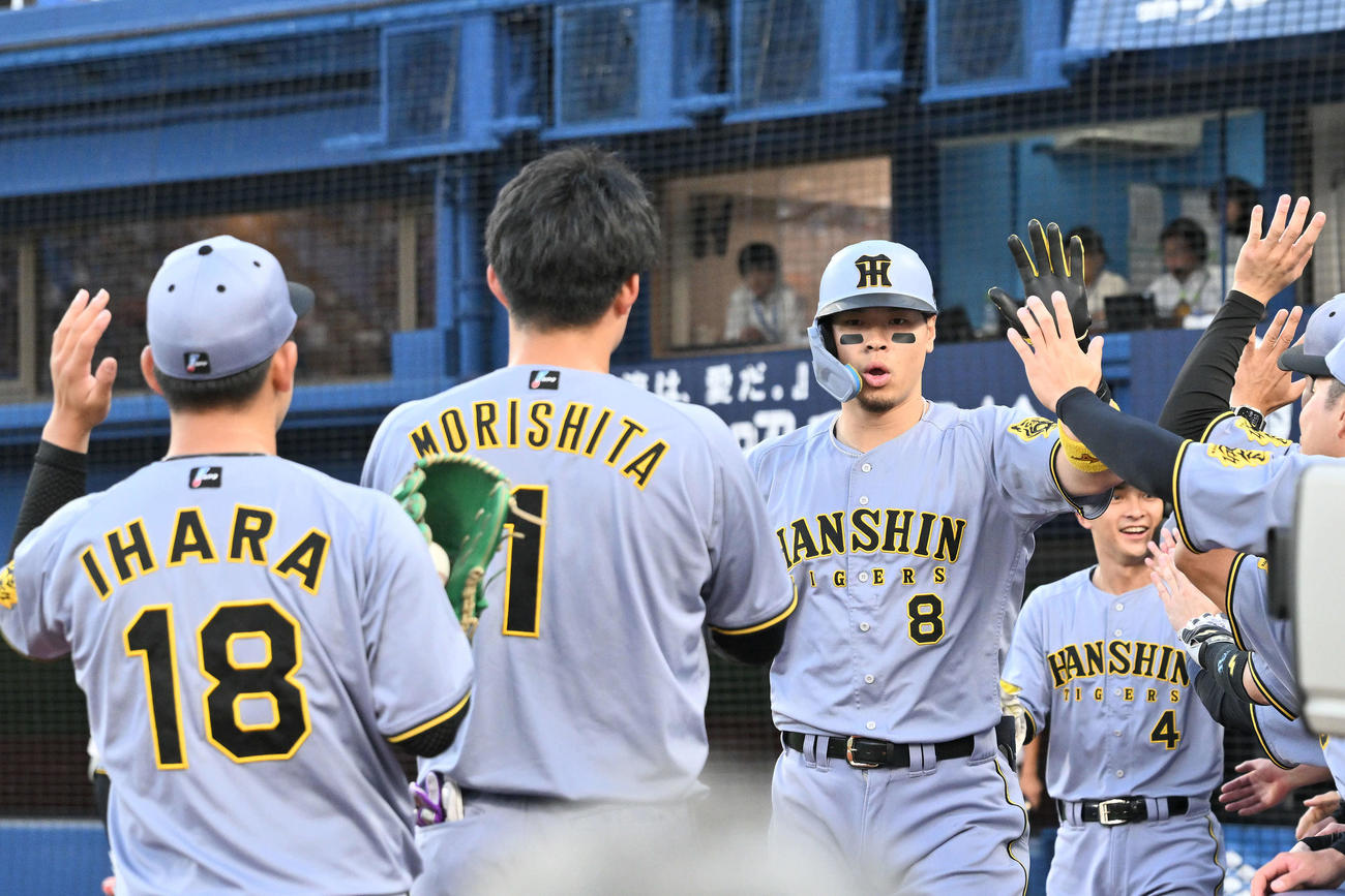 DeNA対阪神　1回表阪神2死二塁、先制2点本塁打を放った佐藤輝（左から3人目）は生還しチームメートとタッチをかわす（撮影・滝沢徹郎）