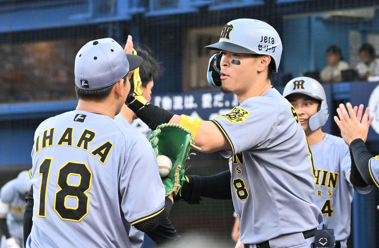 DeNA対阪神　1回表阪神2死二塁、先制2点本塁打を放った佐藤輝（右手前）は生還し伊原とタッチを交わす（撮影・滝沢徹郎）