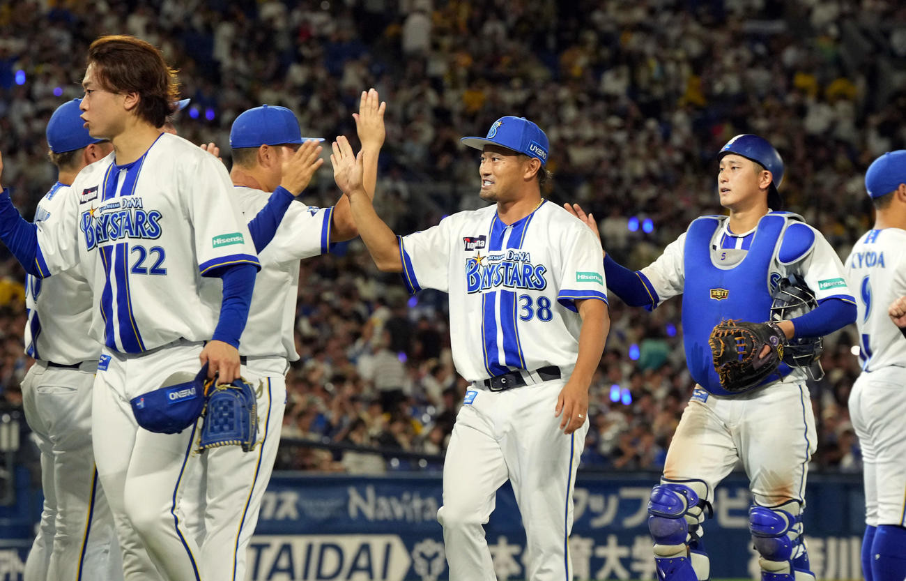 DeNA対阪神　12年連続で勝利を飾り笑顔でナインとハイタッチをするDeNA森唯（中央）（撮影・たえ見朱実）