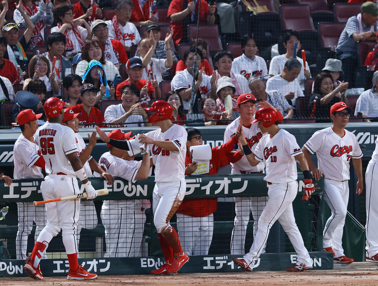 広島対巨人　2回裏広島1死二、三塁、ファビアンの左前2点適時打で生還した佐々木らを出迎える新井監督（右から3人目）（撮影・藤尾明華）