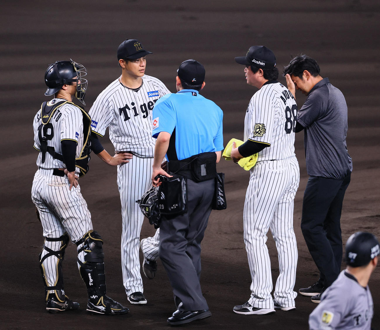 安藤投手チーフコーチ、トレーナーと話しをする大竹（左から2人目）（撮影・藤尾明華）