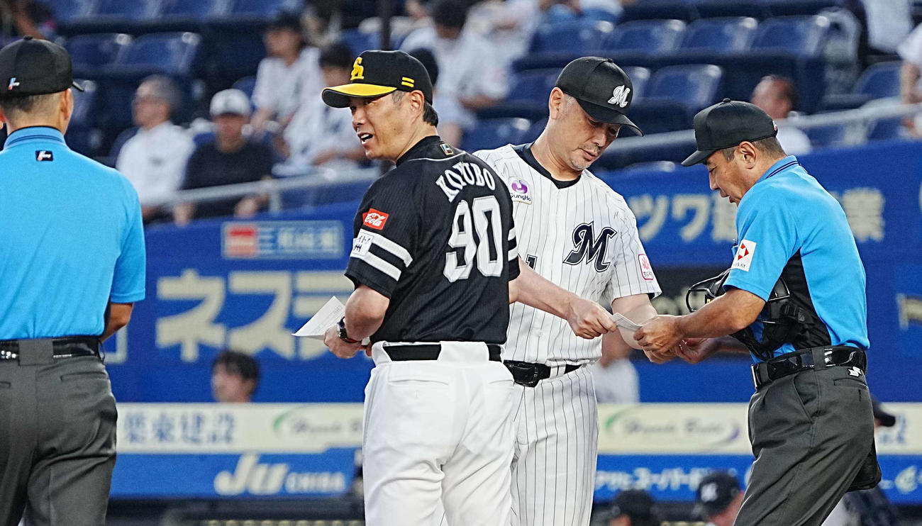ロッテ対ソフトバンク　試合前のメンバー表交換に臨むソフトバンク小久保監督（中央左）とロッテ吉井監督（撮影・小沢裕）