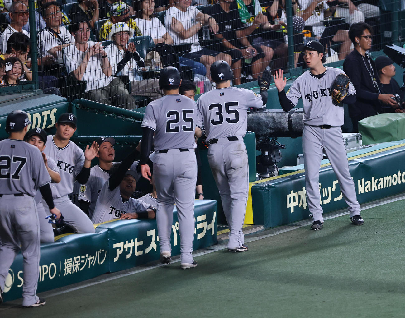 阪神対巨人　6回表巨人1死満塁、キャベッジの走者一掃適時二塁打で生還した泉口らを出迎える山崎伊織（右端）（撮影・藤尾明華）