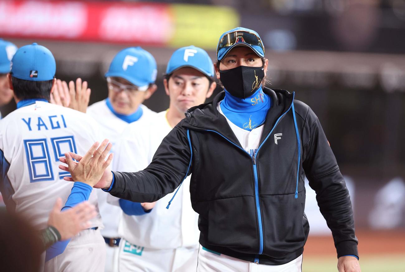 日本ハム対楽天　試合後、スタッフらとタッチする新庄監督（撮影・黒川智章）