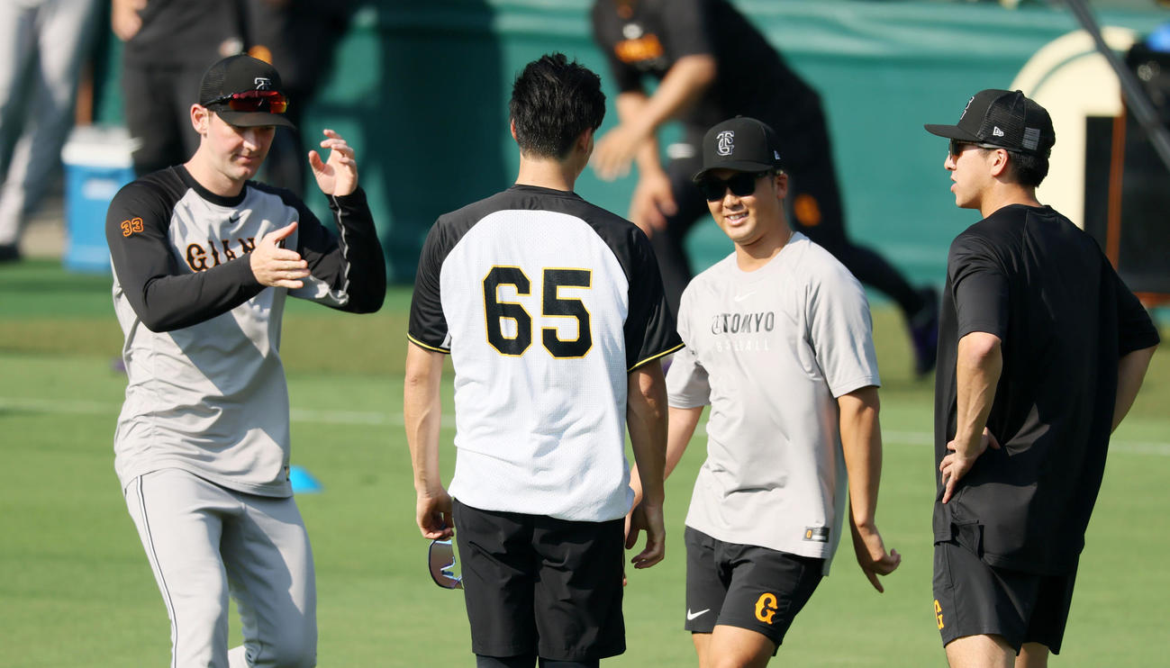 阪神対巨人　練習前、湯浅（左から2人目）にあいさつするケラー（左端）。右端は大勢（撮影・加藤哉）