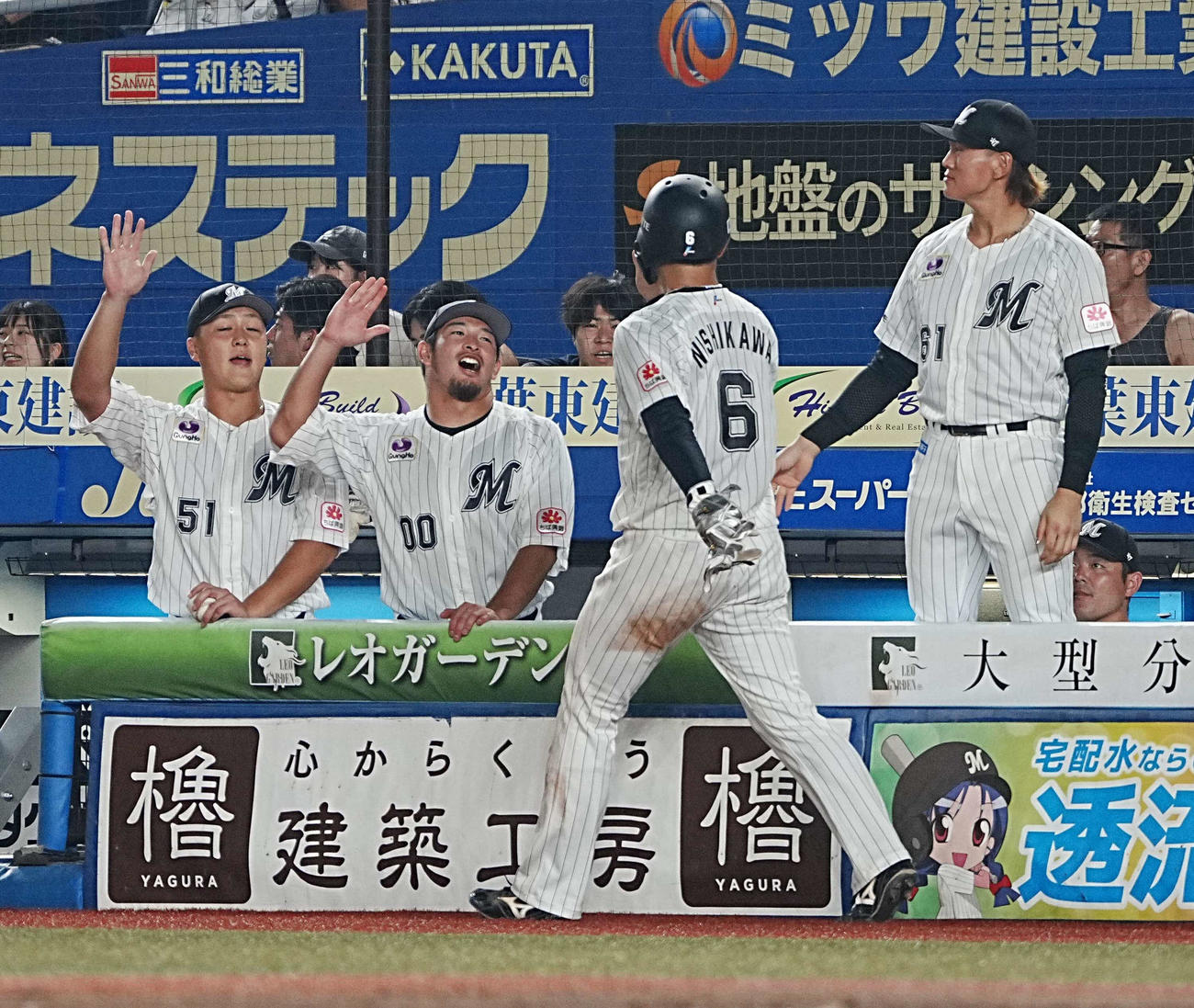 ロッテ対ソフトバンク　6回裏ロッテ1死満塁、藤岡の左前適時打で生還した西川はベンチのナインの祝福を受ける（撮影・小沢裕）