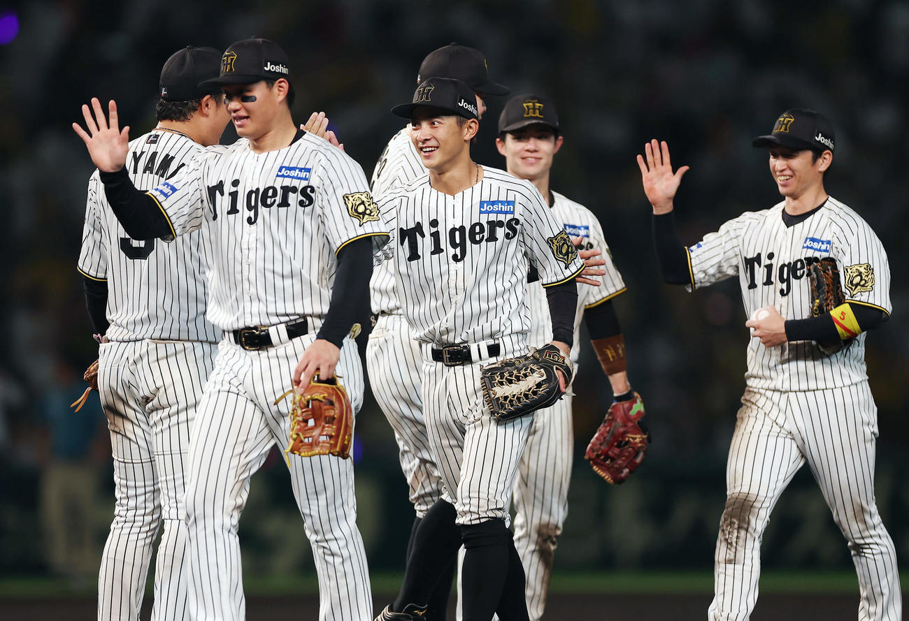 阪神対巨人　巨人に勝利し、タッチを交わす熊谷（中央）ら阪神の選手たち（撮影・前田充）