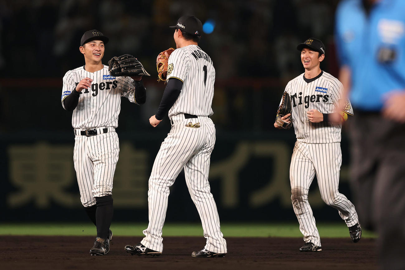 阪神対巨人　巨人に勝利し笑顔でタッチを交わす、左から阪神熊谷、森下、近本（撮影・前田充）