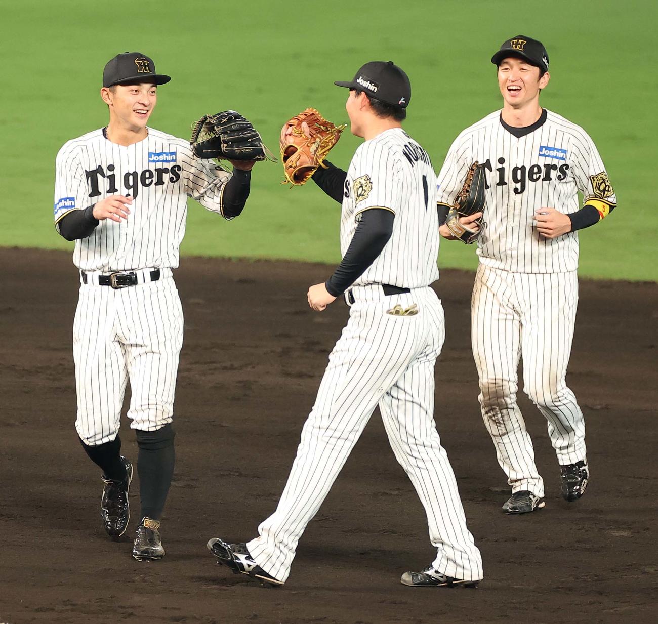 阪神対巨人　攻守に活躍した熊谷（左）は森下（中央）近本と笑顔でグラブタッチをする（撮影・上田博志）