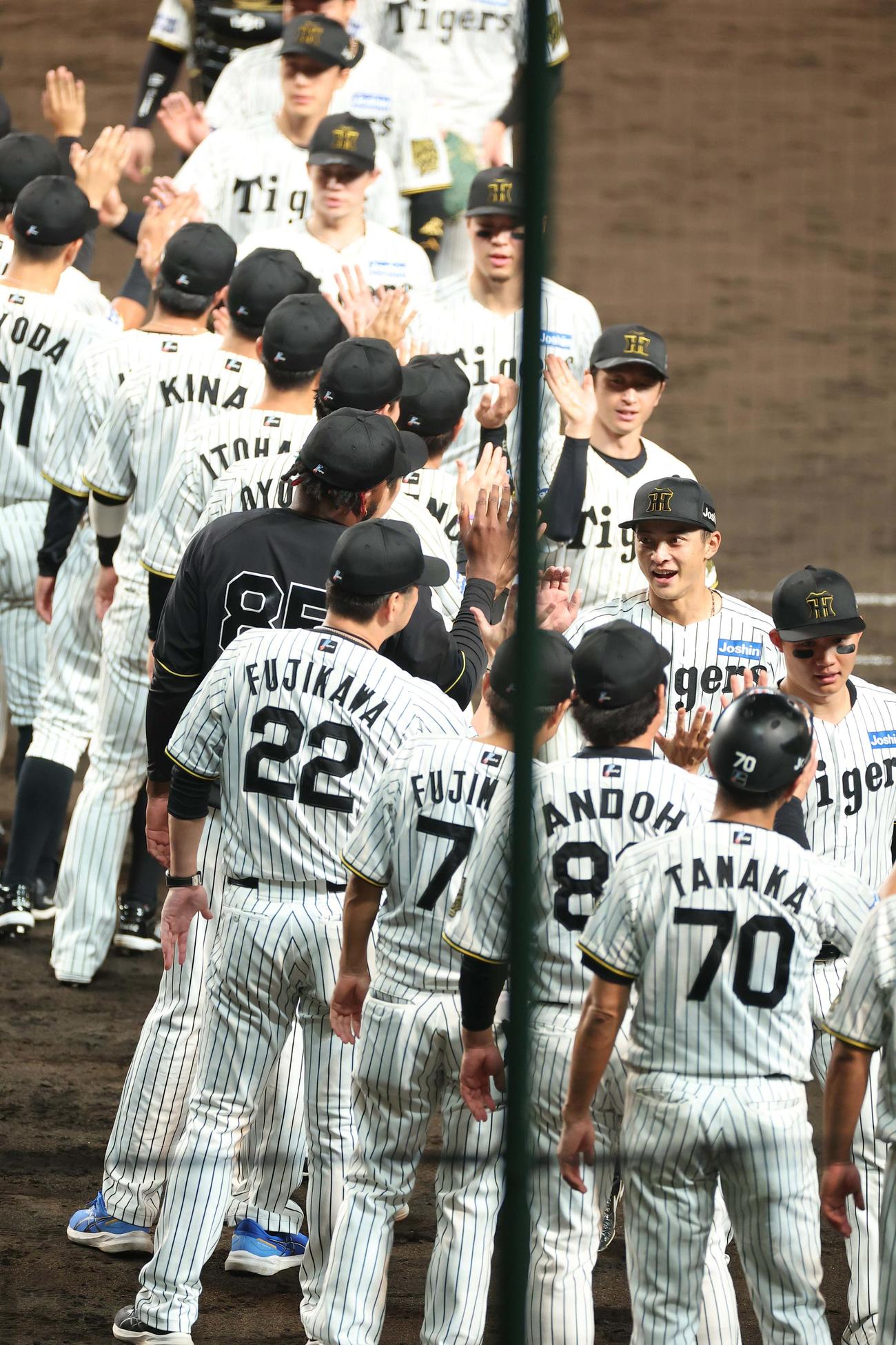 阪神対巨人　攻守で活躍した熊谷（右から2人目）は藤川監督と笑顔でハイタッチする（撮影・上田博志）