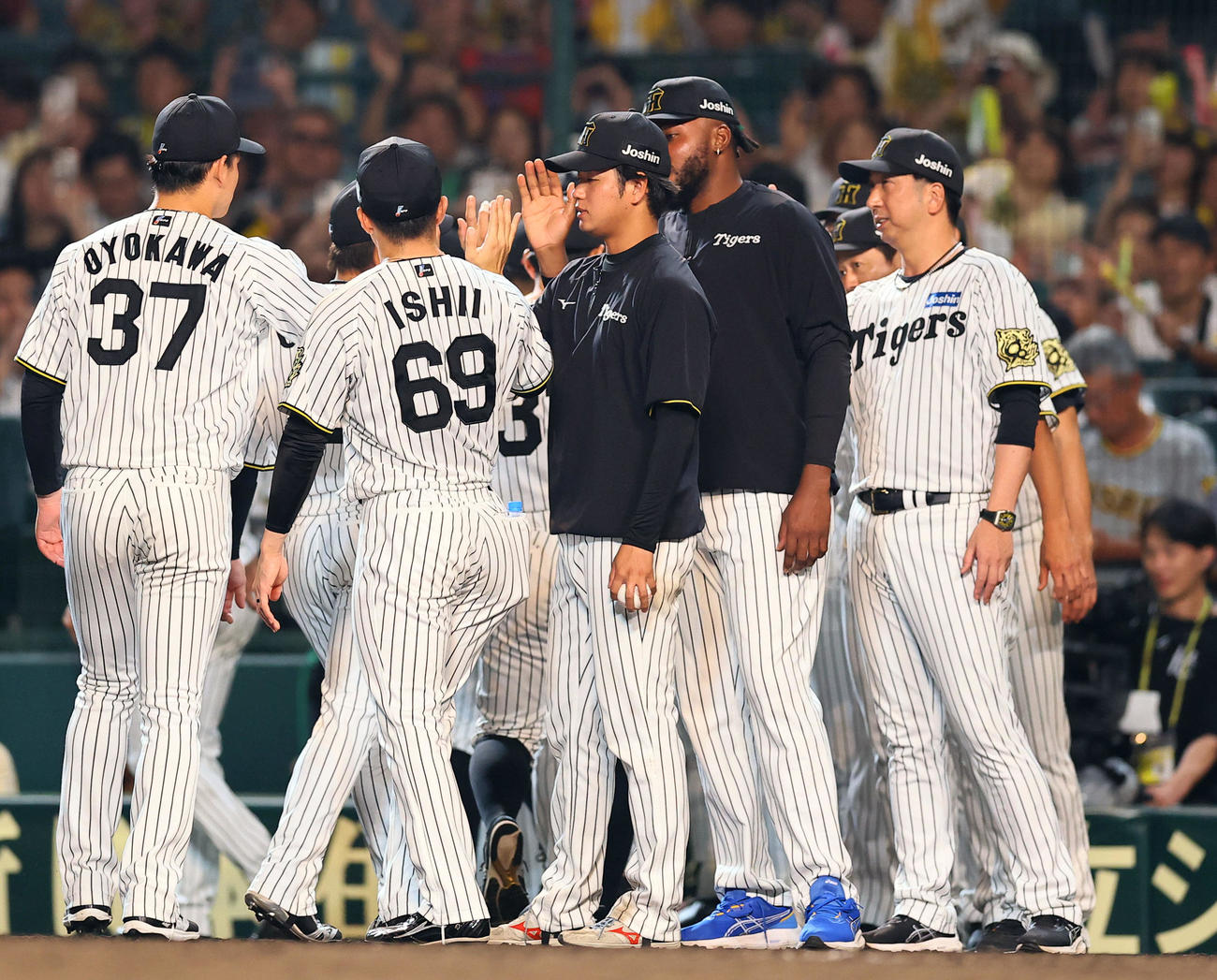 阪神対巨人　巨人に勝利しナインとタッチを交わす阪神高橋（中央）。右は藤川監督（撮影・藤尾明華）