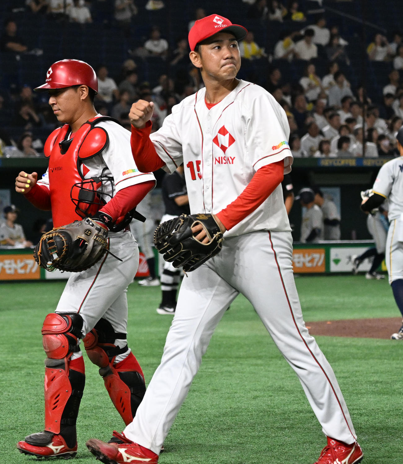 日本生命対西濃運輸　ピンチを逃げ切った1回の投球を終え、拳を握りながらベンチに戻る日本生命・谷脇。左は捕手三島（撮影・千葉一成）