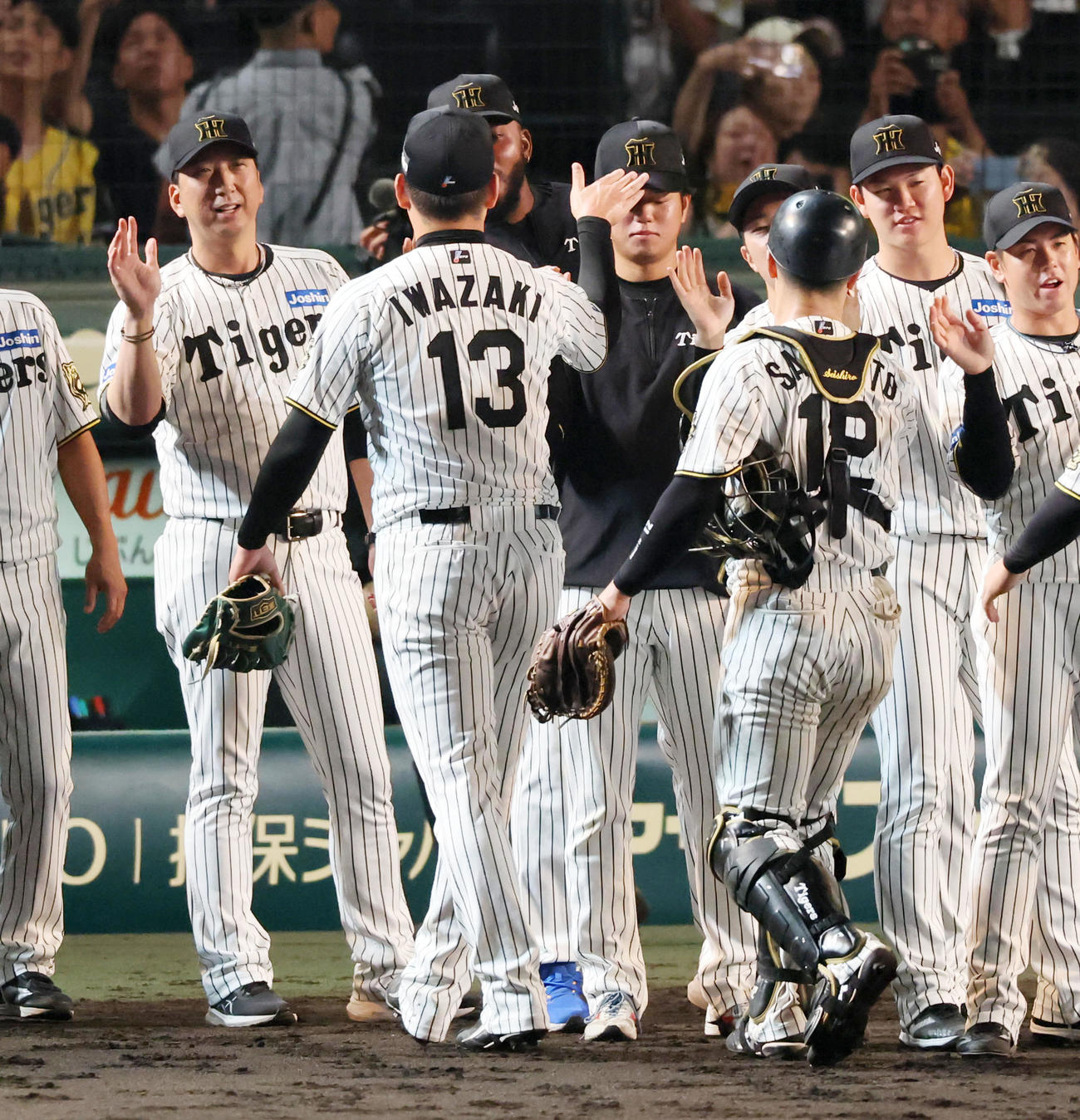 阪神対巨人　岩崎（右）からウイニングボールを手渡された高橋は帽子をポンと叩かれる。左は藤川監督（撮影・加藤哉）