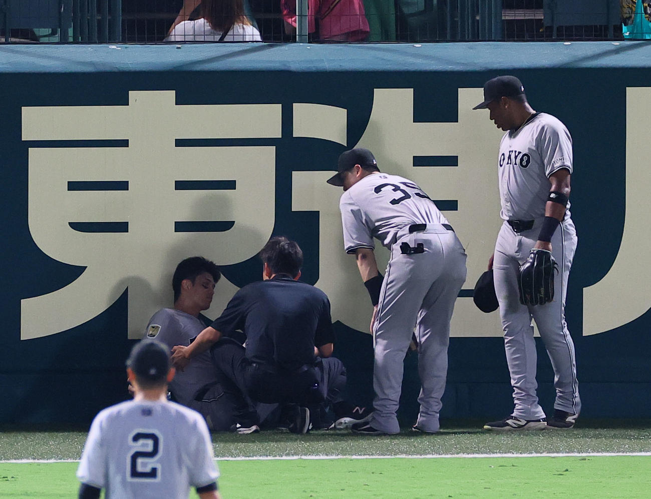 阪神対巨人　7回裏阪神2死二塁、森下の適時三塁打の打球を追って、フェンスに激突し倒れ込む左翼手若林（撮影・藤尾明華）