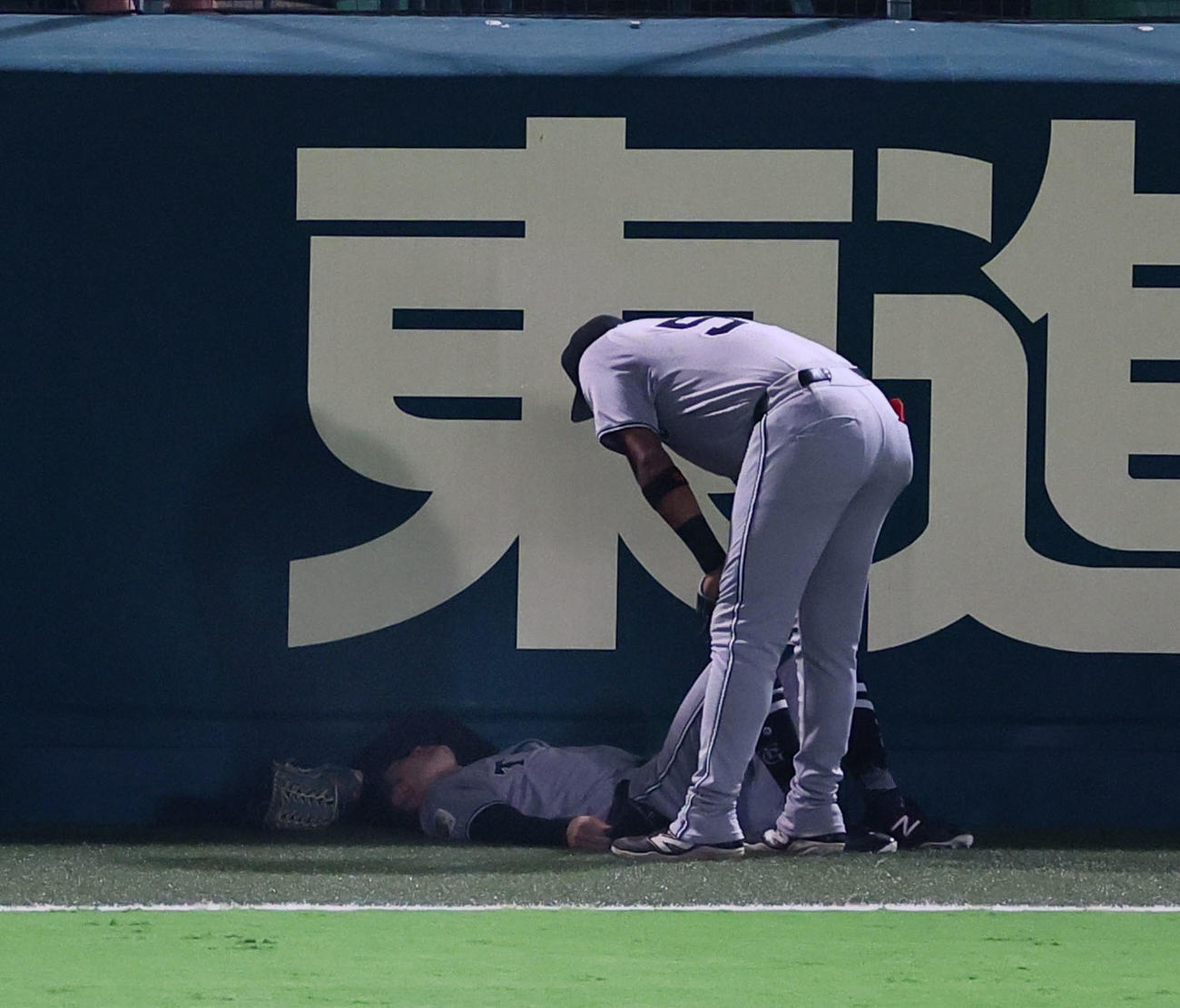 阪神対巨人　7回裏阪神2死二塁、森下の適時三塁打の打球を追って、フェンスに激突し倒れ込む左翼手若林（撮影・藤尾明華）