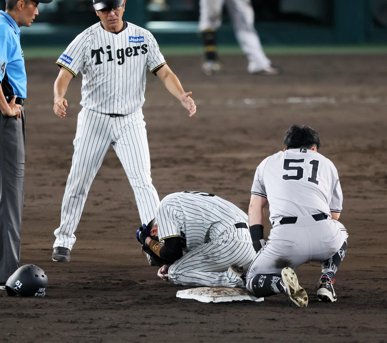 阪神対巨人　9回表巨人2死満塁、代打坂本の野選で佐藤輝からのボールを捕球に行くも逸れ、中野拓夢は一塁走者浅野と接触し頭部を抑える（撮影・加藤哉）