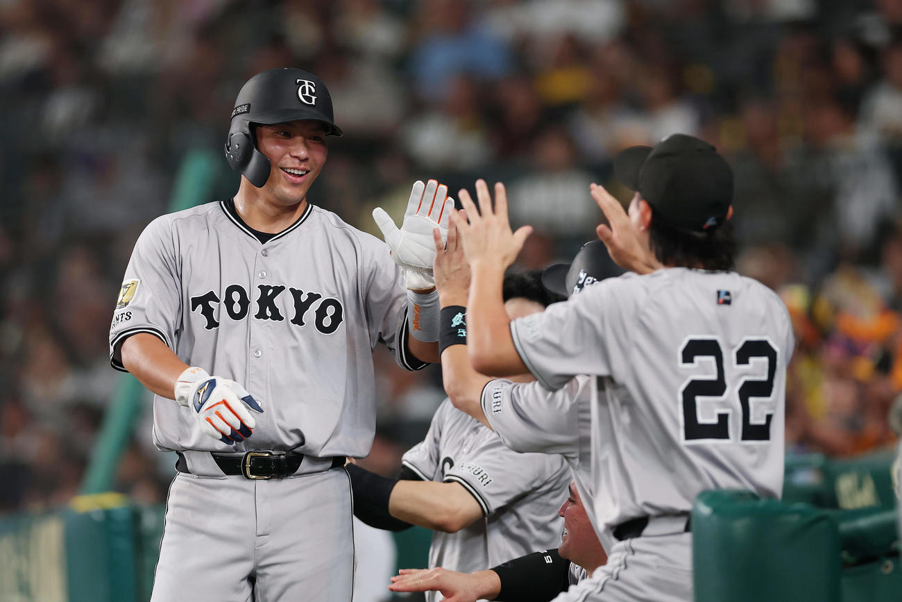 阪神対巨人　7回表巨人2死三塁、若林の勝ち越し適時打で生還し、ナインに迎えられる大城卓（撮影・前田充）