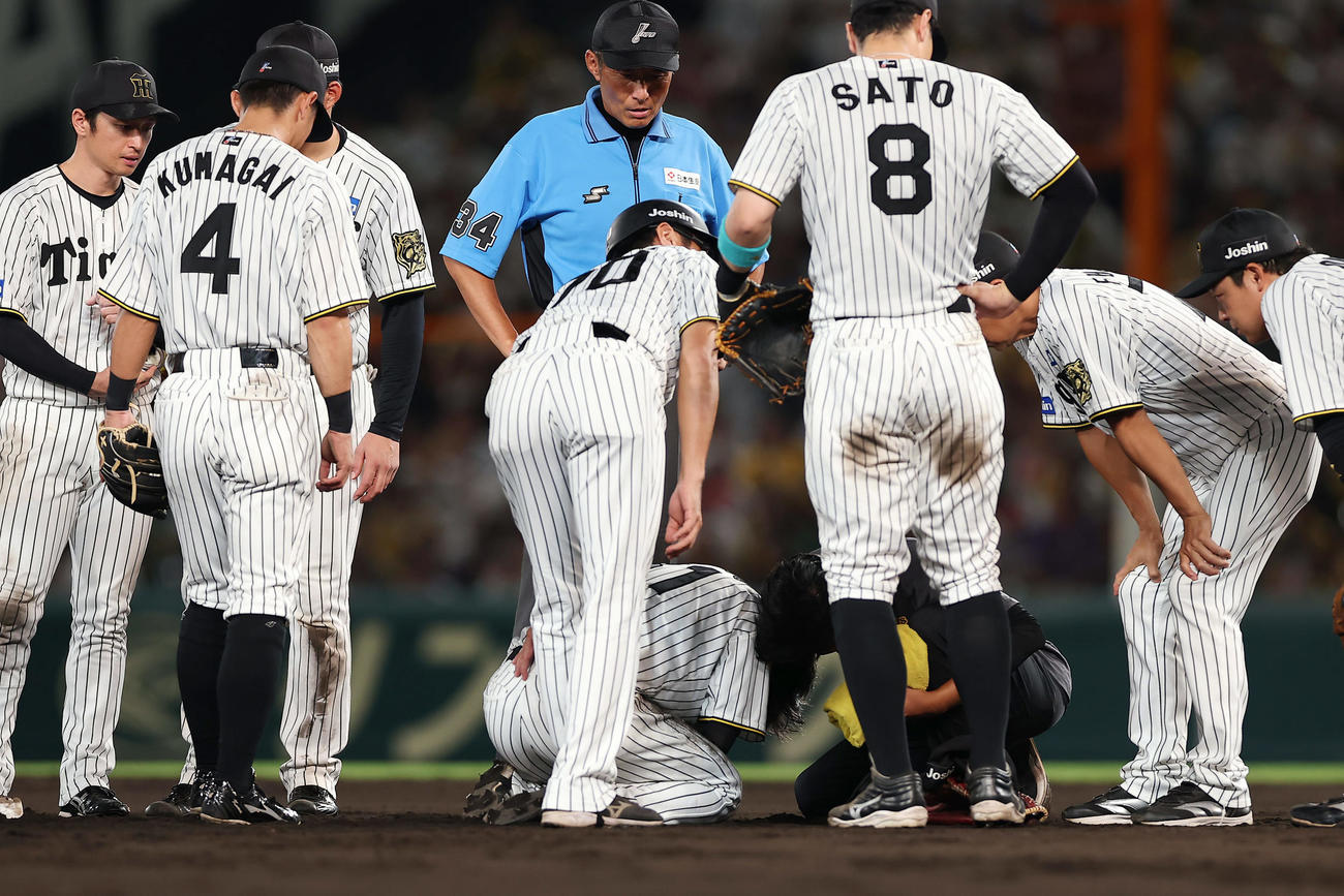 阪神対巨人　9回表巨人2死満塁、坂本の三塁野選の際に一走浅野と交錯し、うずくまる中野（中央下）（撮影・前田充）