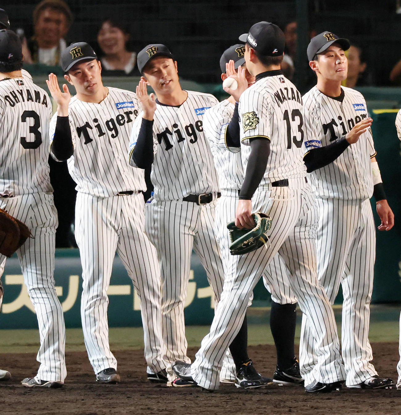 阪神対巨人　勝利投手の島本は岩崎（右）らナインをタッチで迎える。左は石井（撮影・加藤哉）